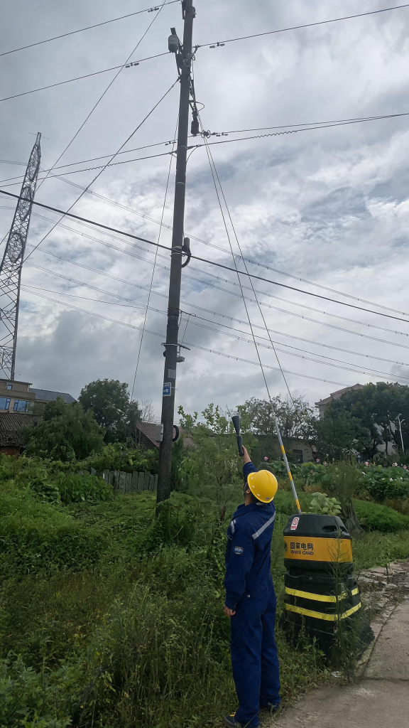 Engineer performing live-line ultrasonic inspection on overhead power line