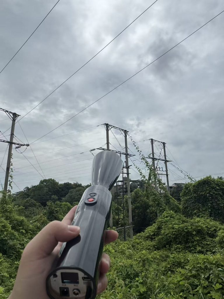 Engineer performing live-line ultrasonic inspection on overhead power line